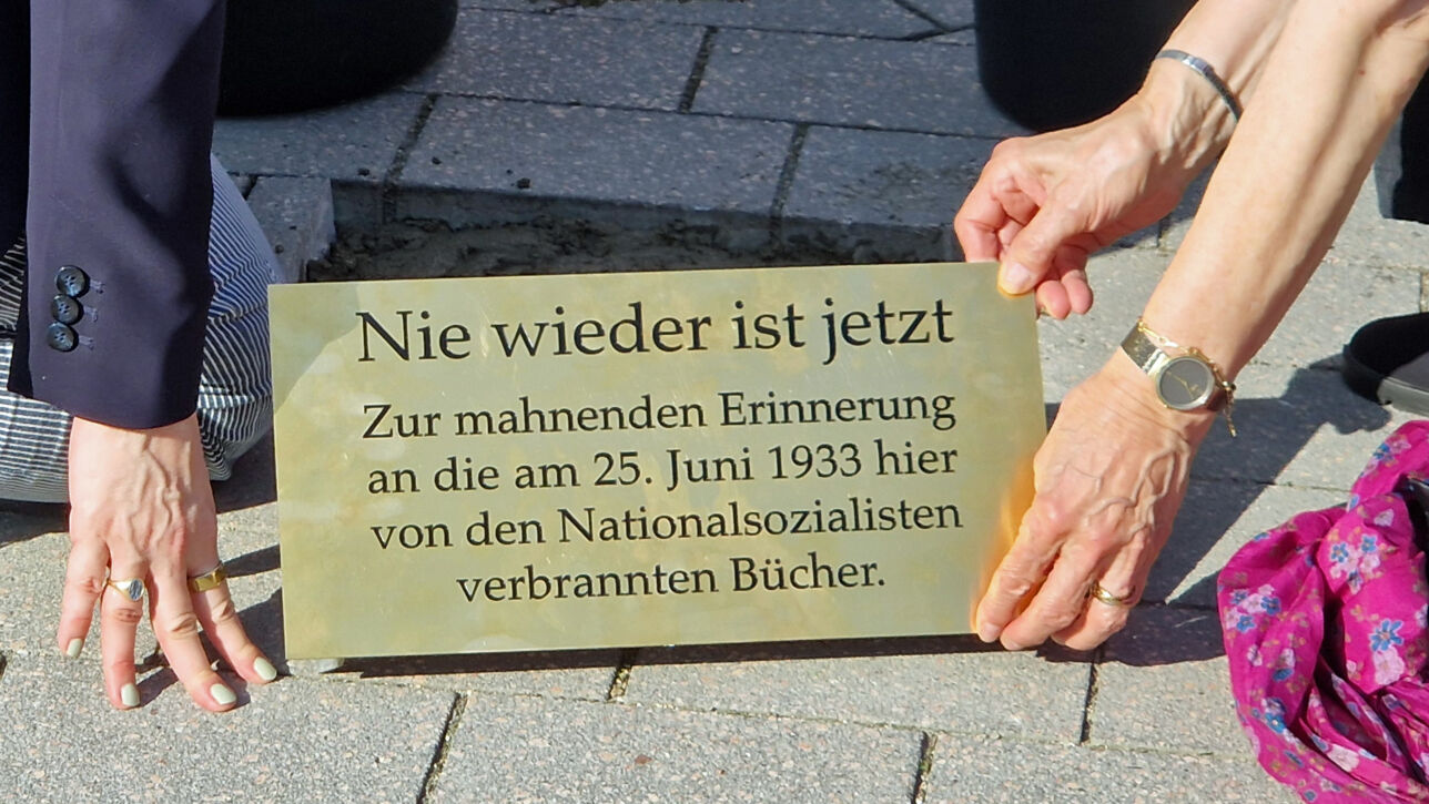 Rozette Kats und Melanie Bernstein verlegen Gedenktafel auf dem Bad Segeberger Marktplatz